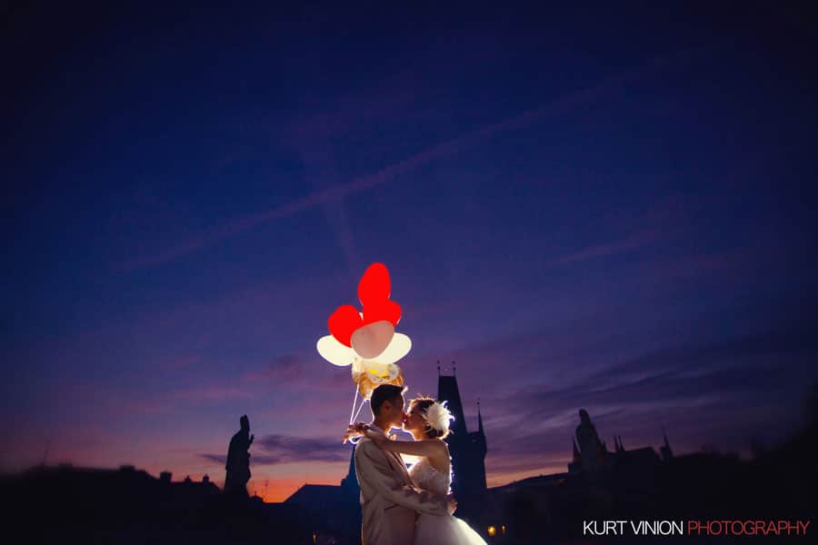 flaring summer sky, red balloons, Charles Bridge, wedding couple kiss at night