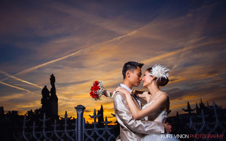 good looking couple, embracing, flaring sky, Charles Bridge sunset, Prague Castle