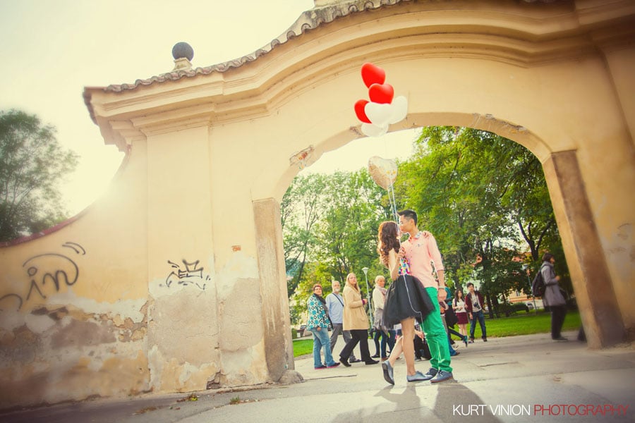 good looking couple, embracing, red & white balloons, Kampa Park, Prague, sun flare