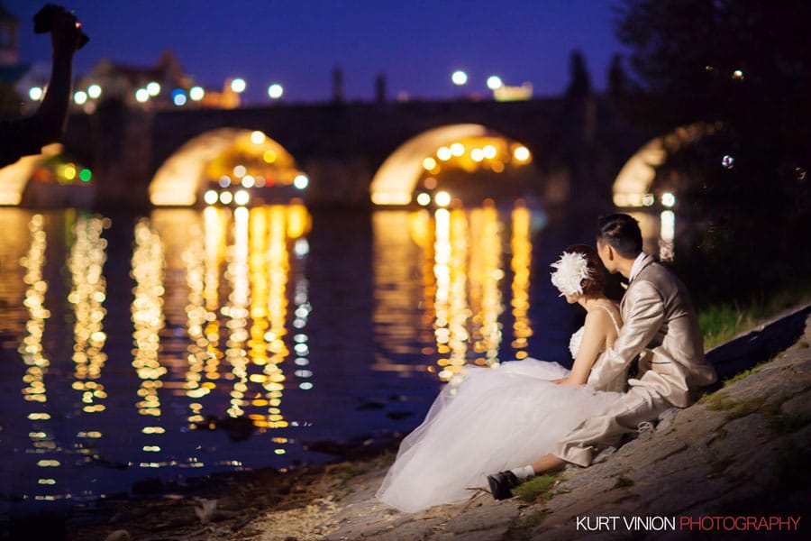 good looking couple, wedding clothes, sitting near Charles Bridge, night portrait, water reflection, Prague
