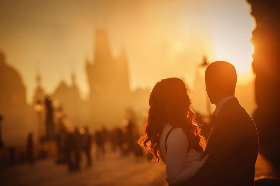 Prague Charles Bridge sunrise, Golden & Orange color, sun flare, moody, couple embracing