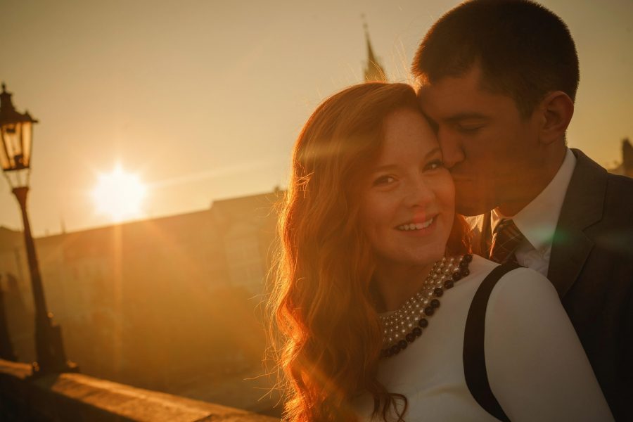 Prague Charles Bridge sunrise, Golden & Orange color, sun flare, smiling young couple