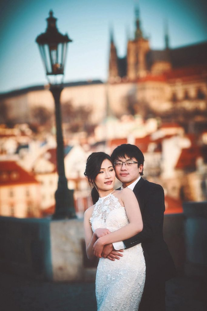A simple portrait of a young couple in their wedding clothes on the Charles Bridge during their pre-wedding photo shoot.