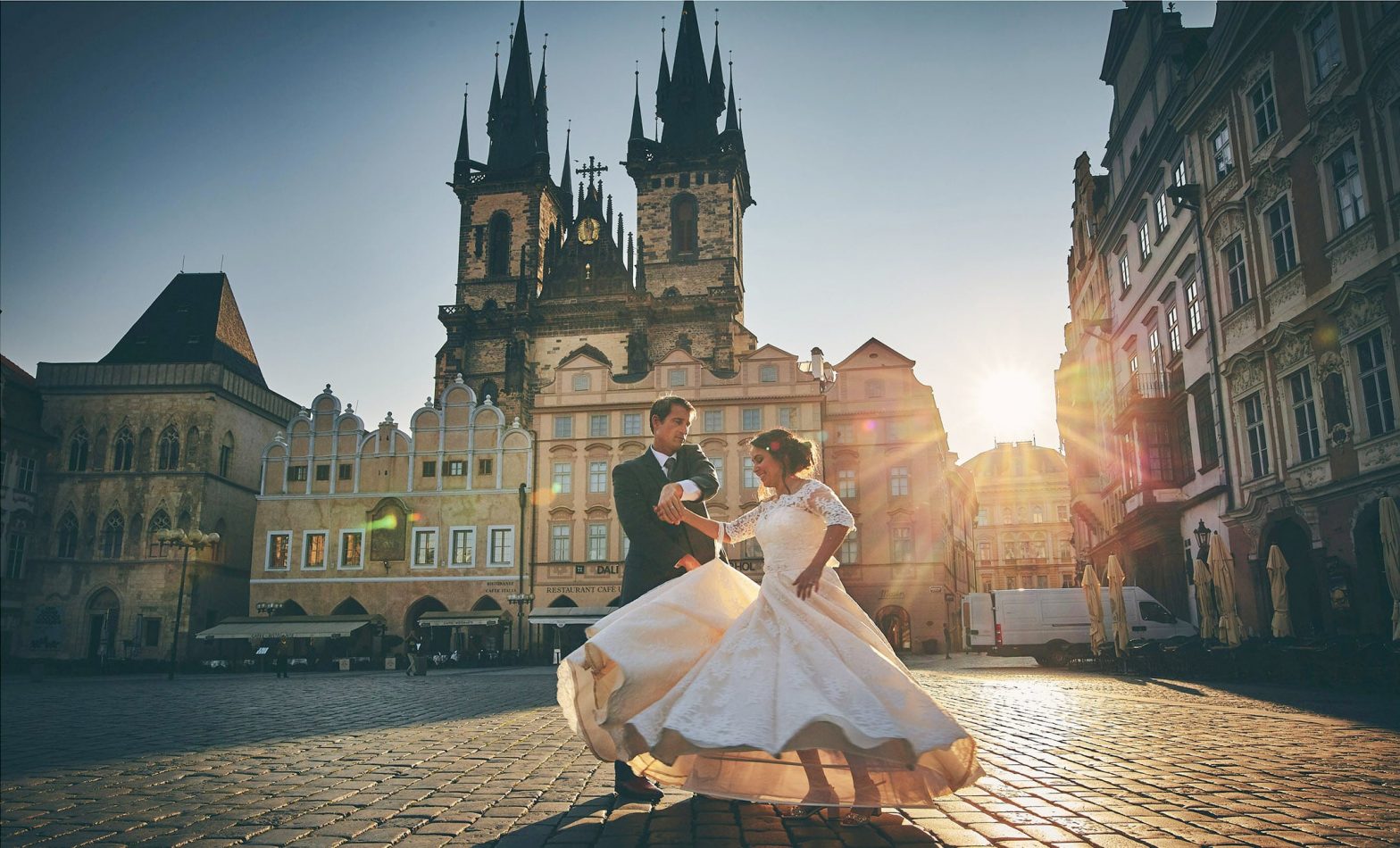 couple dancing as the sun flares beautifully around them in the Old Town Square on their wedding day!